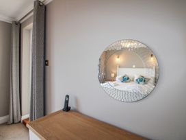 A bedroom with a mirror and a bed at 7 Thurlestone Rock in Thurlestone