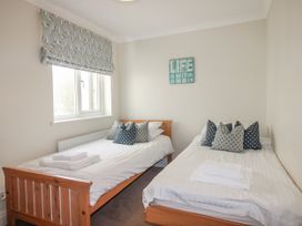 A bedroom with two beds and pillows at 7 Thurlestone Rock in Thurlestone