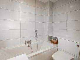 A bathroom with a bath tub and toilet at 7 Thurlestone Rock in Thurlestone