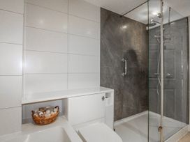 A bathroom with a shower and bathtub at 7 Thurlestone Rock in Thurlestone