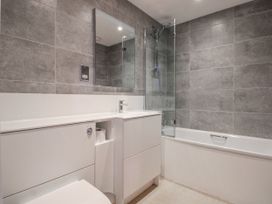 A bathroom with a sink, toilet, bath, and shower at 7 Thurlestone Rock in Thurlestone