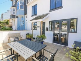 An outdoor seating area with a table and chairs at Armada Cottage Dartmouth