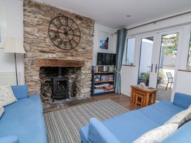 A living room with a fireplace and bookshelves at Armada Cottage in Dartmouth