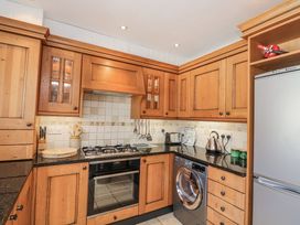 A kitchen with wooden cabinets and appliances at Armada Cottage Dartmouth