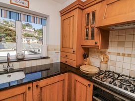 A kitchen with sink and cabinets at Armada Cottage in Dartmouth
