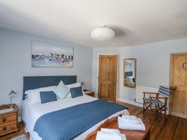 A bedroom with a bed and a bedside table at Armada Cottage Dartmouth