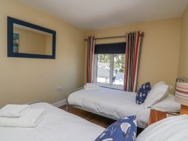 A bedroom with two beds and a window at Armada Cottage in Dartmouth