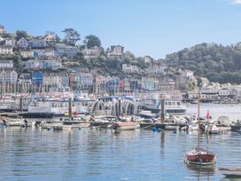 A harbor with boats and buildings along the waterfront at Armada Cottage Dartmouth