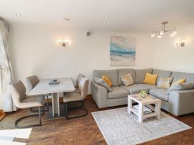 A living room with a sofa and dining area at 6 Court Cottage, Hillfield Village Dartmouth