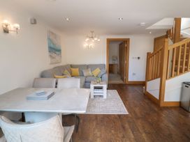 A living room with a sofa and dining table at 6 Court Cottage, Hillfield Village Dartmouth