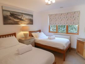 A bedroom with two beds and a lamp at 6 Court Cottage, Hillfield Village Dartmouth
