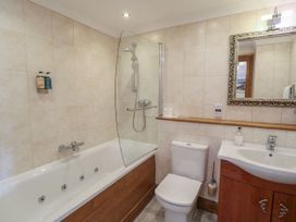 A bathroom with a bathtub and shower at 6 Court Cottage, Hillfield Village in Dartmouth
