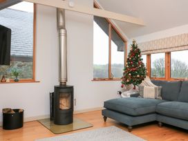 A living room with a stove and sofa at Courtyard Cottage in Dartmouth