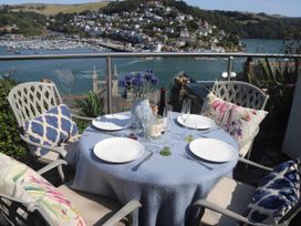 An outdoor dining area with a table set near a waterfront at Dart Views in Dartmouth