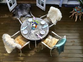An outdoor dining table with chairs and a floral arrangement at Dart Views in Dartmouth