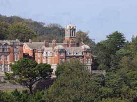 A large building with trees in the foreground at Dart Views in Dartmouth