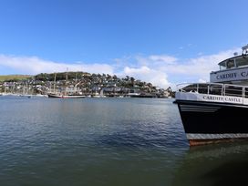 A boat in water with buildings on a hill at Dart Views in Dartmouth