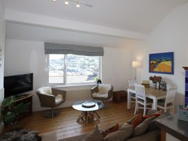 A living room with a television and dining table at Dart Views in Dartmouth