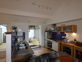 A kitchen with a sink, stove, refrigerator, and door leading to an outdoor area at Dart Views in Dartmouth
