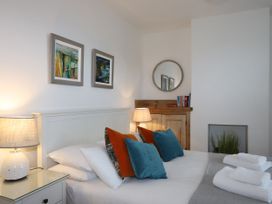 A bedroom with a bed and paintings on the wall at Dart Views in Dartmouth