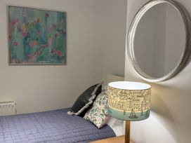 A bedroom with a bed and a mirror at Dart Views in Dartmouth