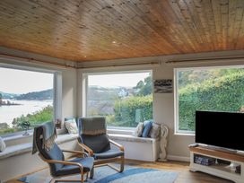 A living room with a sofa and chairs at Dolphins in Salcombe
