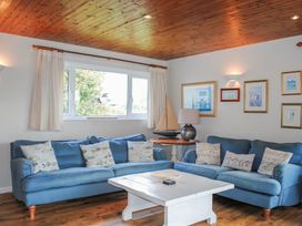 A living room with a sofa and table at Dolphins in Salcombe