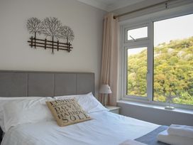 A bedroom with a bed and a window at Dolphins in Salcombe