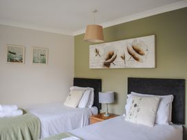 A bedroom with two beds and wall art at Dolphins in Salcombe