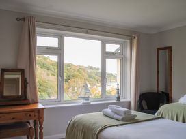 A bedroom with a bed and window at Dolphins in Salcombe