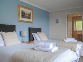 A bedroom with two beds and a bathroom at Dolphins in Salcombe
