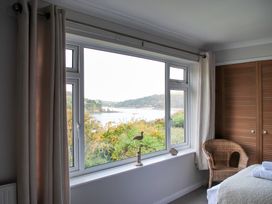 A bedroom with a window overlooking a river at Dolphins in Salcombe