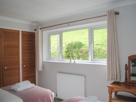 A bedroom with a bed and a window at Dolphins in Salcombe
