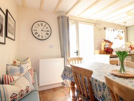 A dining room with a table and chairs at Orchard Barn Salcombe