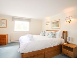 A bedroom with a bed and bedside table at Orchard Barn Salcombe