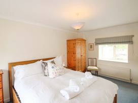 A bedroom with a bed and wardrobe at Orchard Barn Salcombe