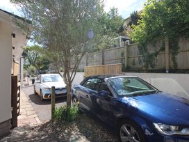 An outdoor view with two cars parked beside a tree at Rock Point in Salcombe