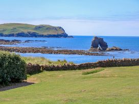 A coastal view with rock formations and grass at Savernake in Thurlestone