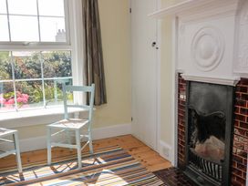 A sitting room with two chairs and a fireplace at Savernake in Thurlestone