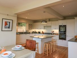 A kitchen with table and chairs at Savernake in Thurlestone