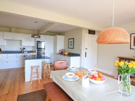 A kitchen with a dining table and fruit at Savernake Thurlestone
