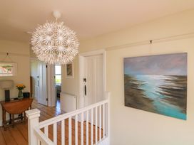 A hallway with a chandelier and painting at Savernake in Thurlestone