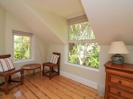 A sitting room with two chairs and a table at Savernake in Thurlestone