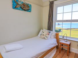 A bedroom with a single bed and a view of the sea at Savernake in Thurlestone