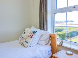 A bedroom with a bed and window at Savernake in Thurlestone