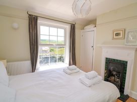 A bedroom with a bed and window at Savernake in Thurlestone