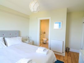 A bedroom with a bed and en-suite bathroom at Savernake in Thurlestone