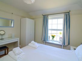 A bedroom with a bed and wardrobe at Savernake in Thurlestone