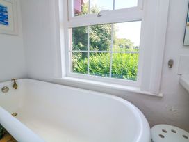 A bathroom with a bathtub and a window at Savernake in Thurlestone