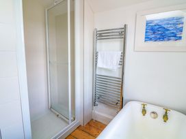 A bathroom featuring a shower, bathtub, and towel rail at Savernake in Thurlestone